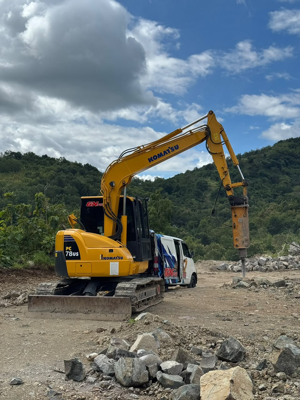 Excavator CV GN PUTRA dengan breaker di area perbukitan